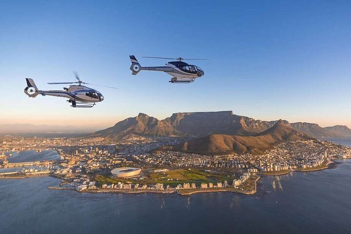Two helicopters flying over Cape Town, Table Mountain, the stadium, and the waterfront